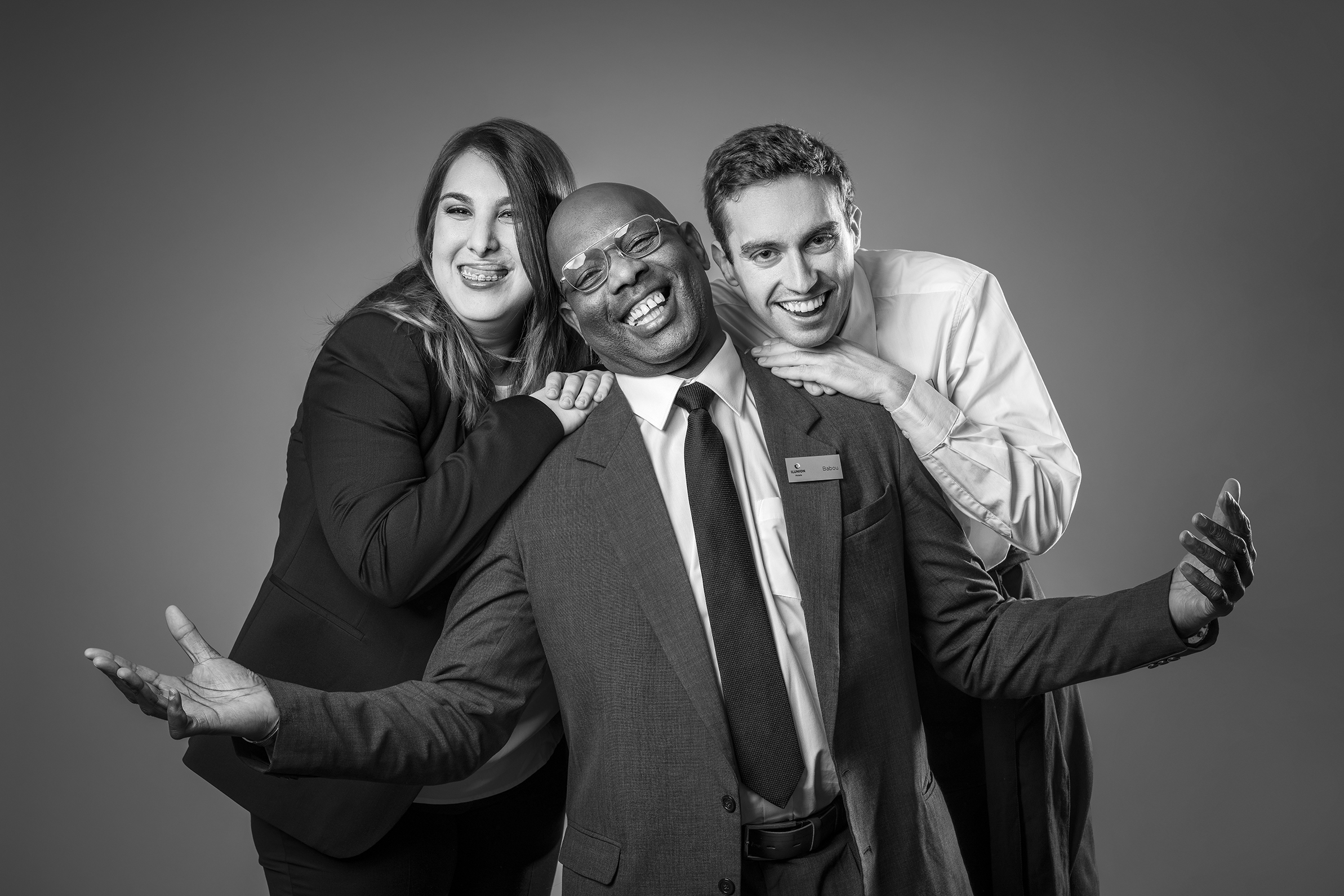 Fotografía en blanco y negro en la que aparecen tres personas sonriendo