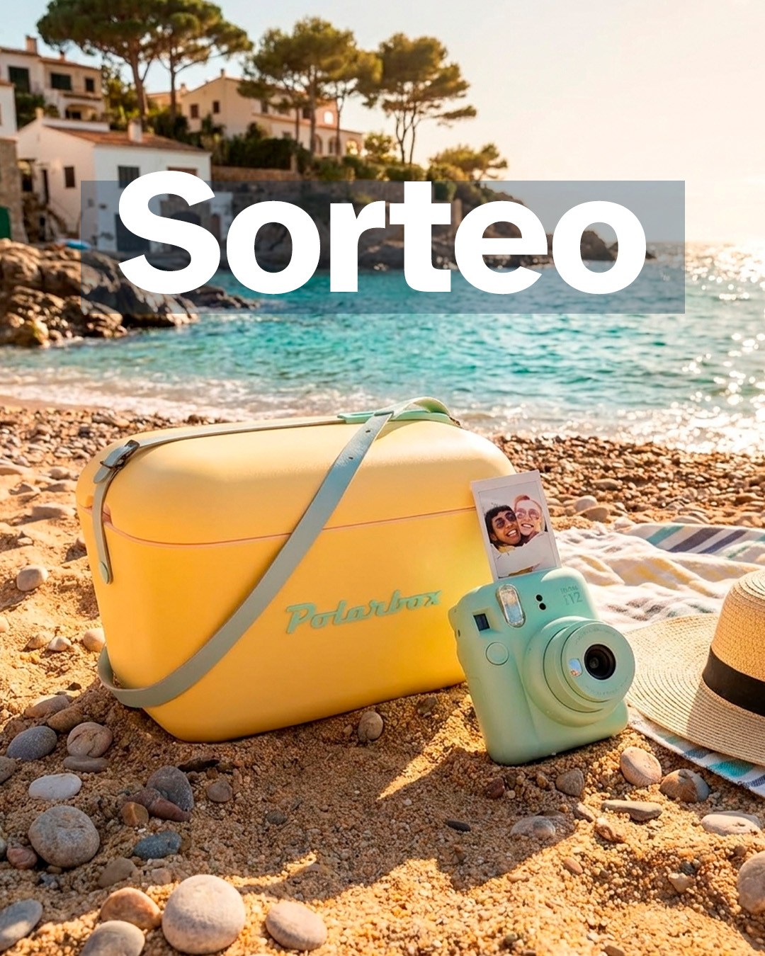 “Sorteo” sobre una escena de playa con nevera amarilla Polarbox y cámara instantánea verde en la arena junto al mar.