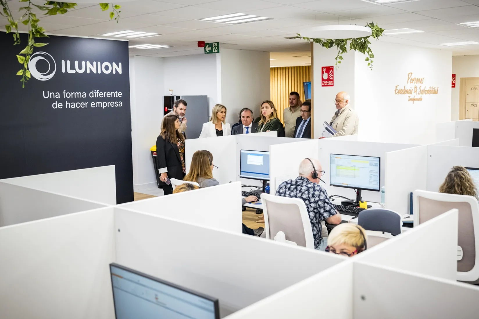 La alcaldesa de Alcorcón, acompañada por la delegación de ILUNION y representantes de ONCE, observa una de las estancias de la nueva oficina de contact center de ILUNION en Alcorcón