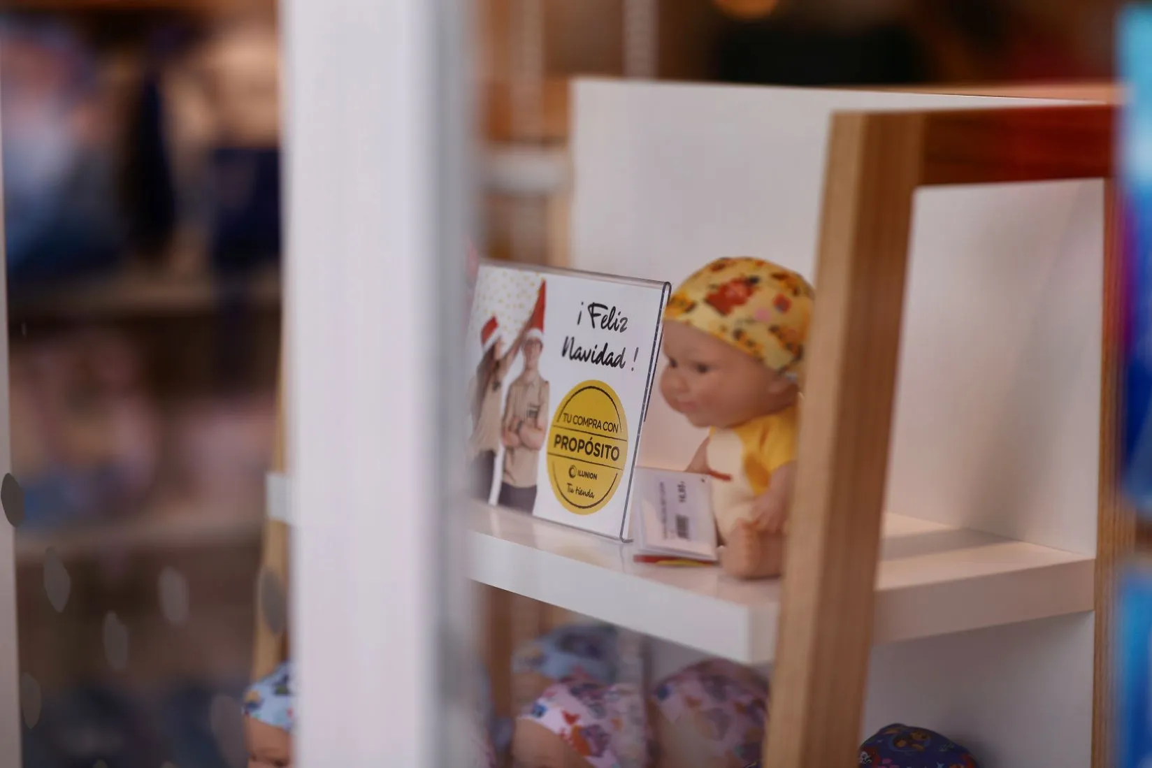 Fotografía de un baby pelón, de Juegaterapia, junto a un cartel que reza Feliz Navidad
