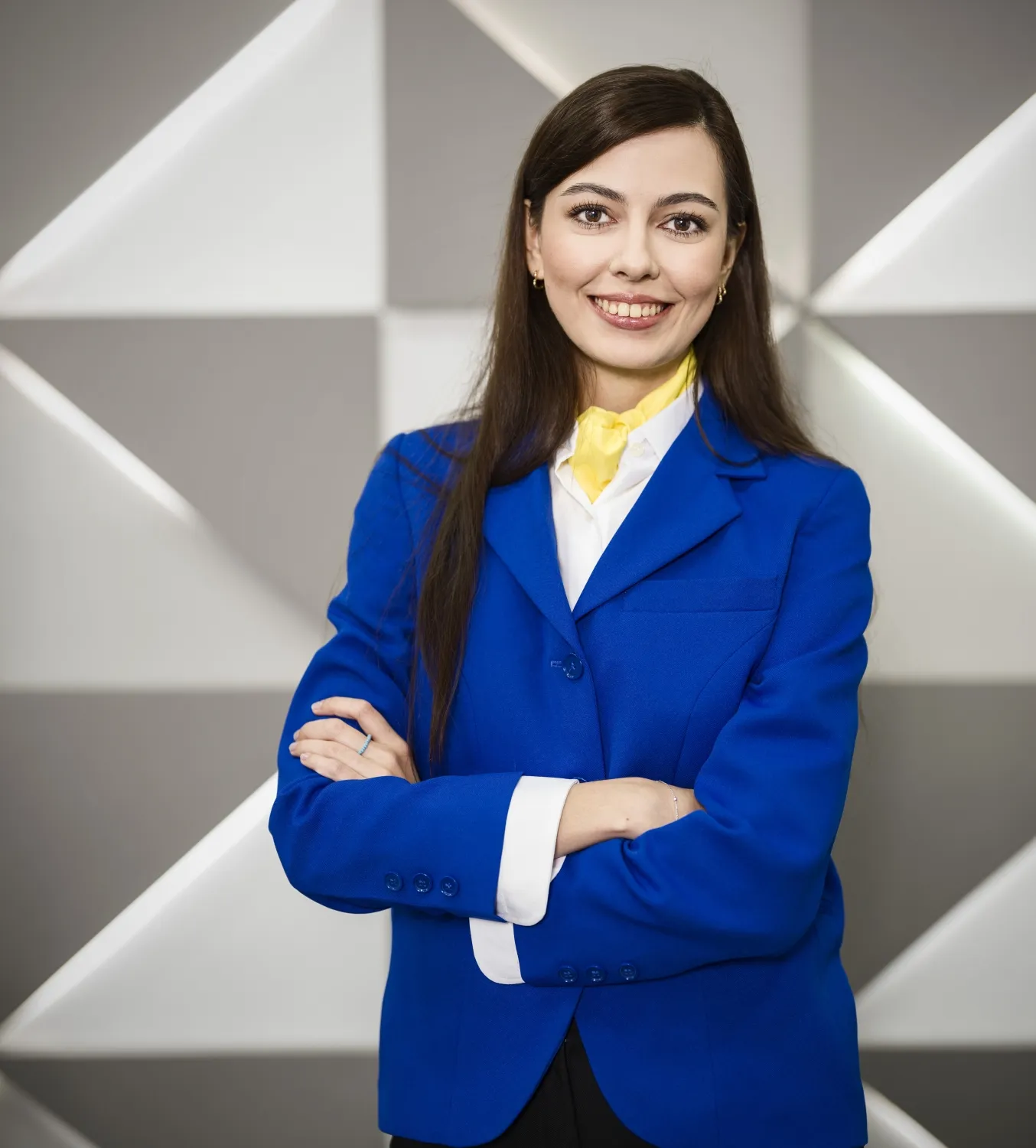 Profesional de recepción del equipo ILUNION atendiendo con una sonrisa en el mostrador corporativo.