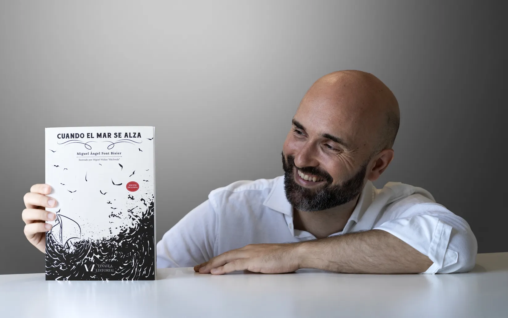 El autor del libro posa sonriente, junto a un ejemplar de su libro 'Cuando el mar se alza'