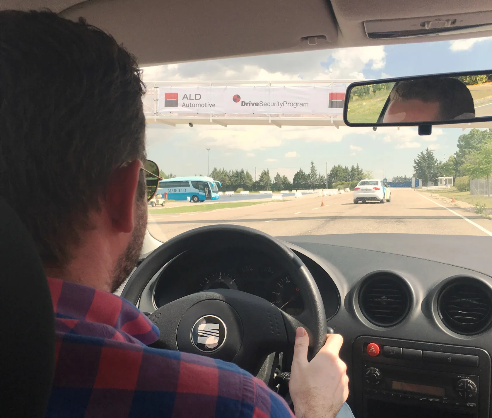 El autor del post, en una foto desde la parte trasera de un coche, coge el volante del coche con sus manos 