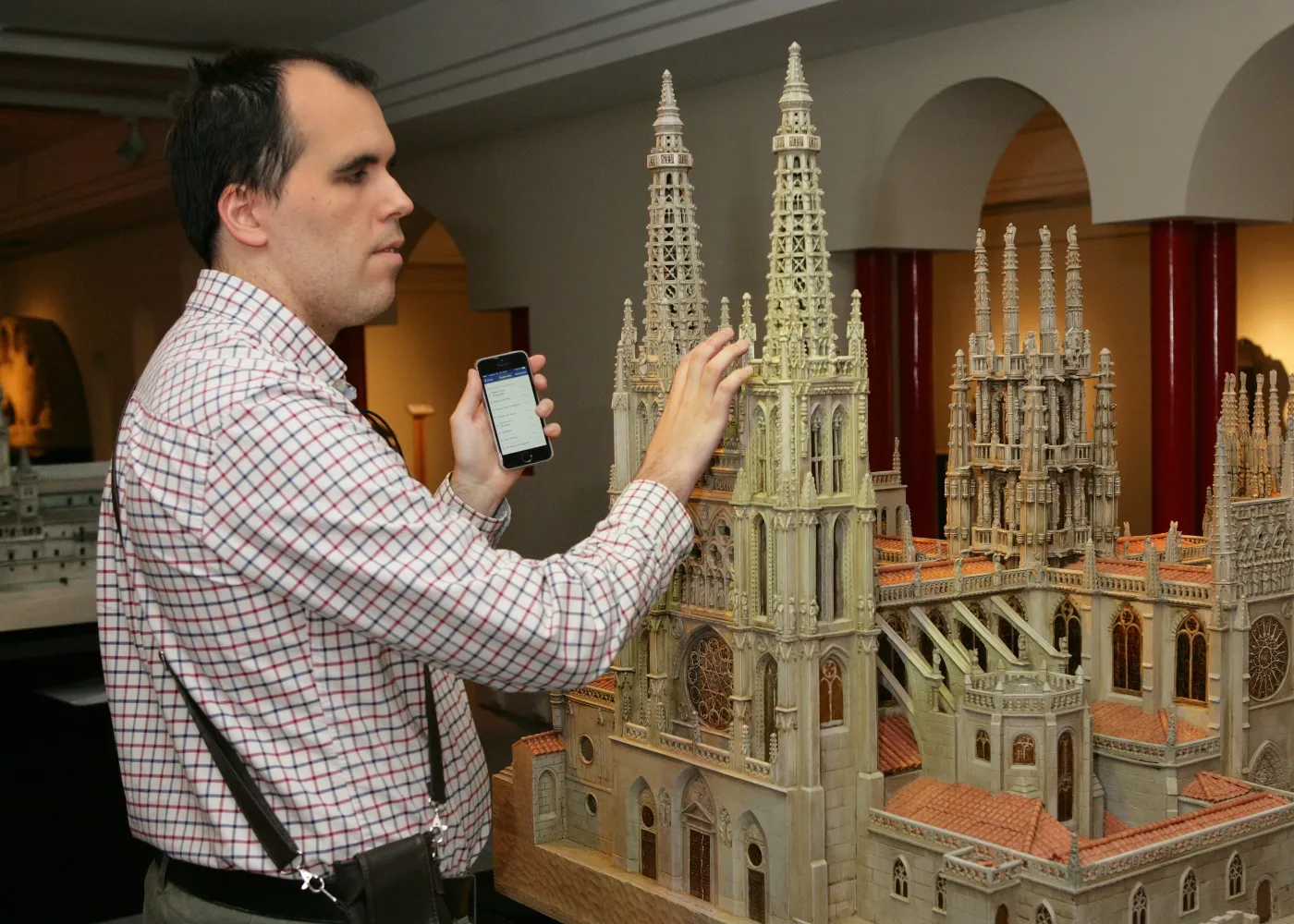 Una persona ciega, con su móvil, utiliza el sistema beepcon para recibir información en el Museo Tiflológico de la ONCE