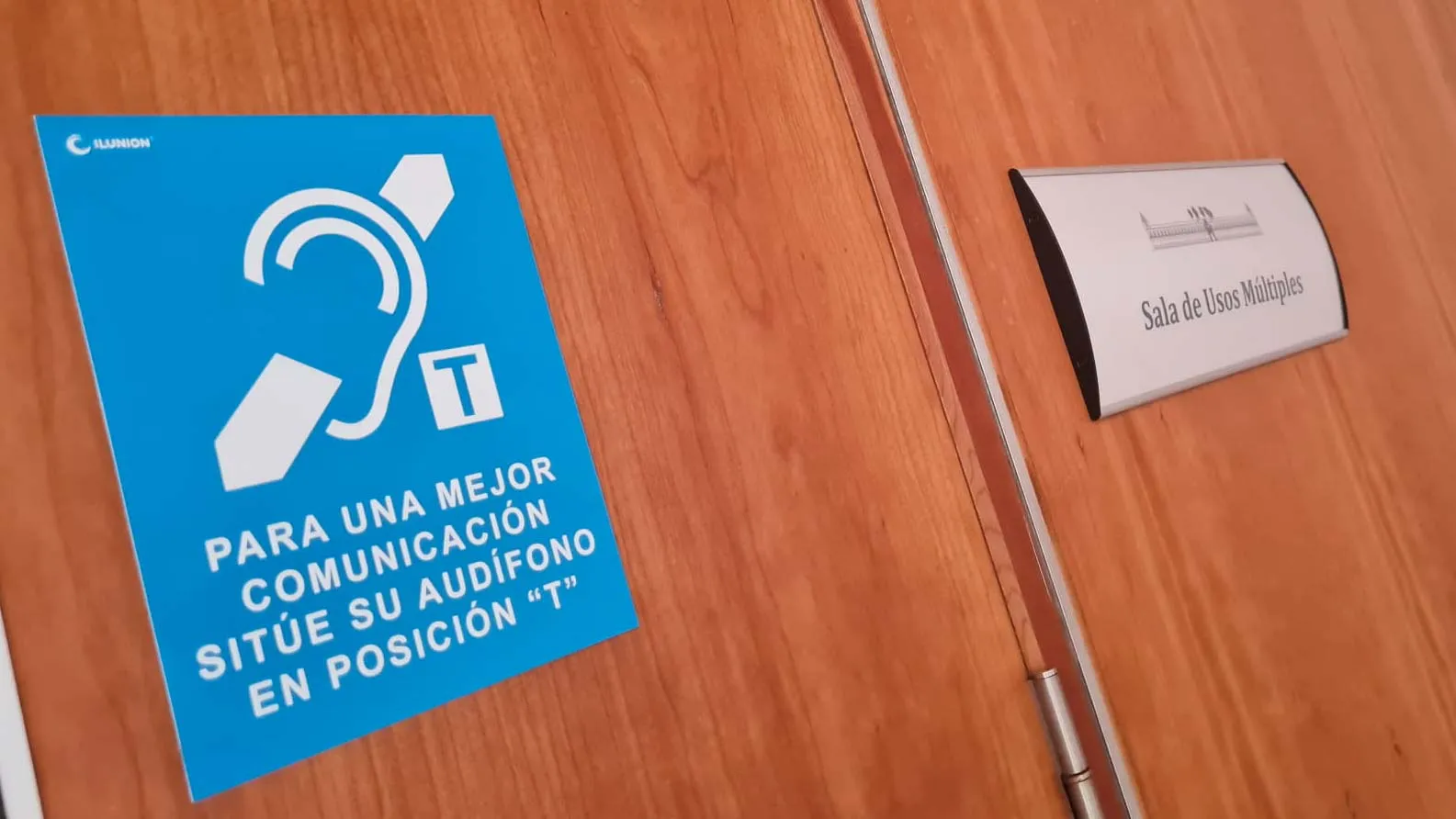 Un cartel en la entrada de la Sala Multiusos del Parlamento de Andalucía indica la instalación de un bucle magnético