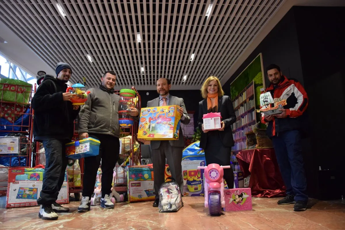 Foto de familia de representantes de ILUNION y la asociación Traperos de Emaús Madrid en el momento de la entrega de juguetes  