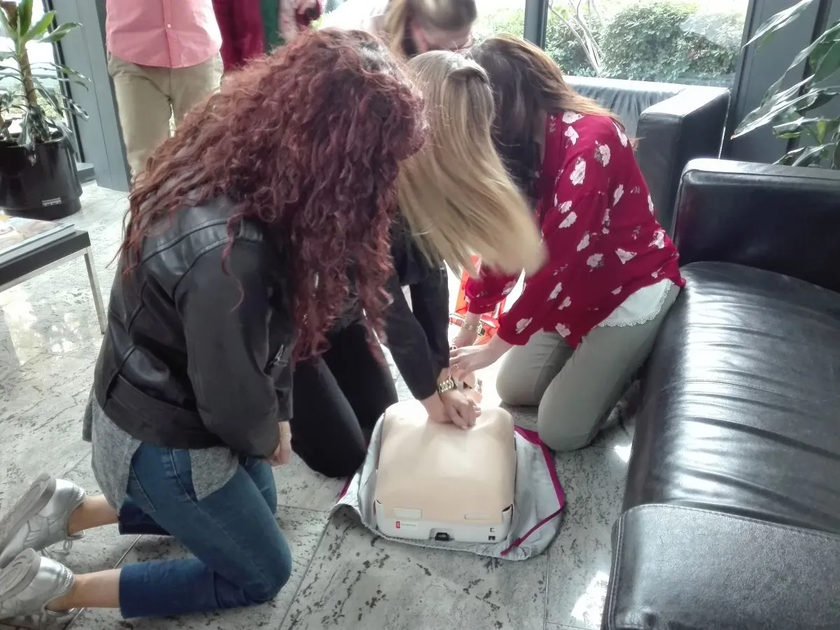 Cuatro trabajadores del Grupo que forman parte de los equipos de primeros auxilios y de emergencia de la compañía, durante el simulacro, en la recepción del edificio Mizar 
