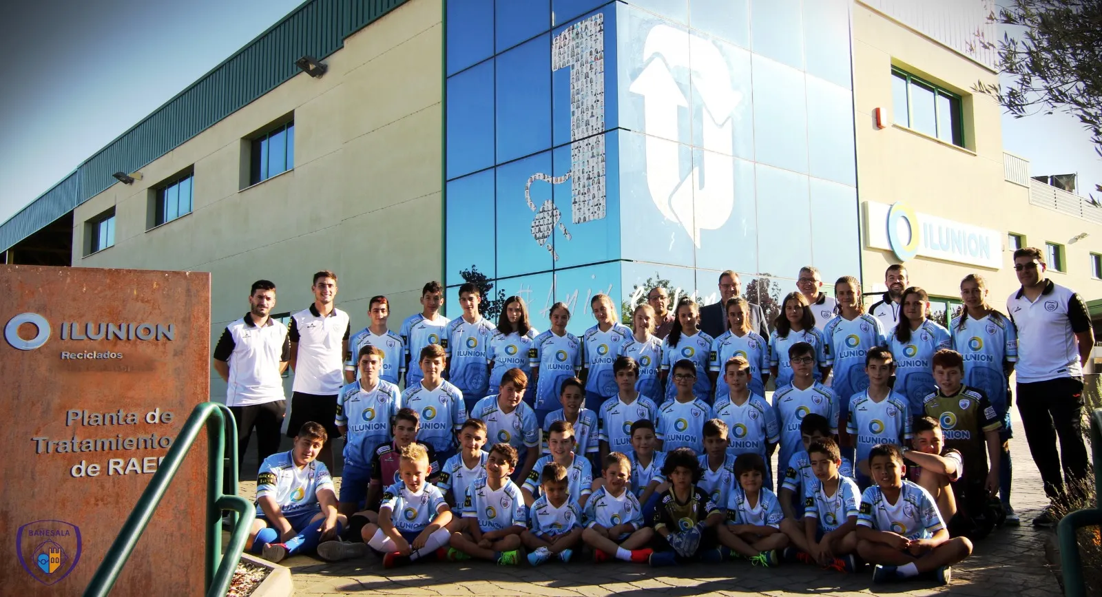 Fotografía de familia de los equipos de fútbol del Club Deportivo Bañesala en el exterior de las instalaciones de ILUNION Reciclados en La Bañeza