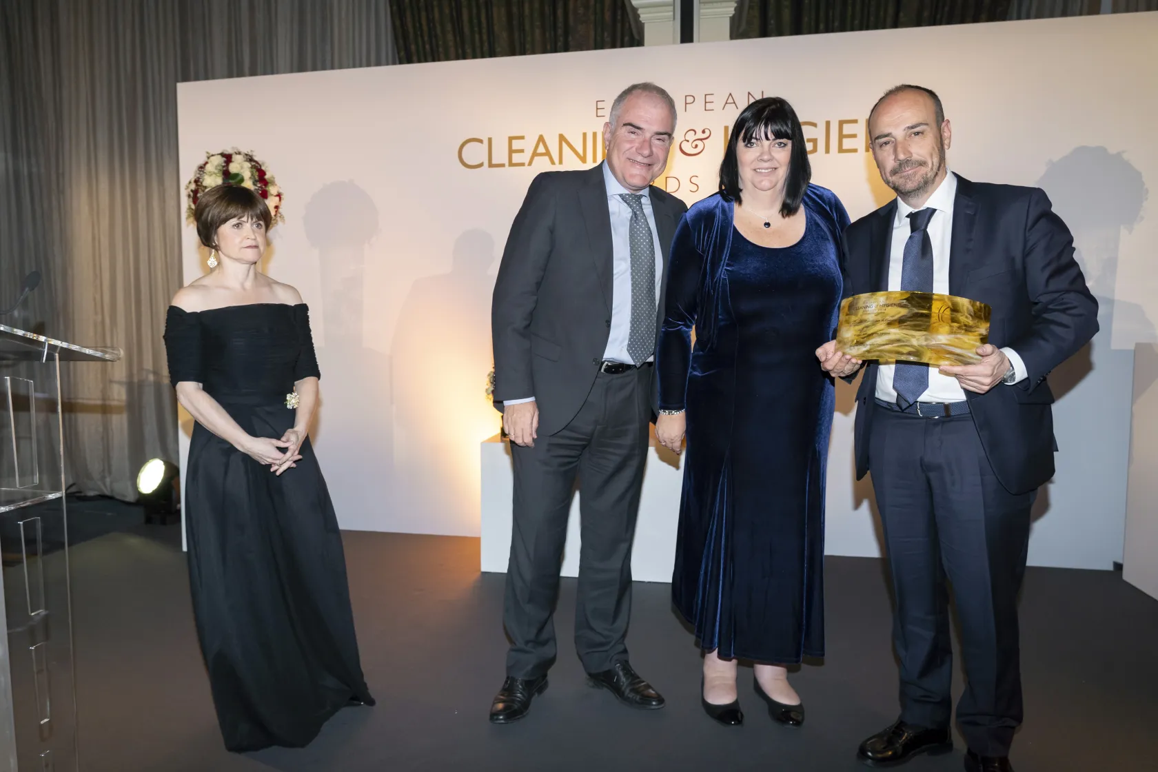 fotografía de la entrega (A la izquierda, Jaime Calzado, director general de ILUNION Facility Services, a la derecha, Rogelio Barrios, gerente nacional del área de Limpieza y Medio Ambiente de la compañía, junto a las encargadas de entregar el premio)