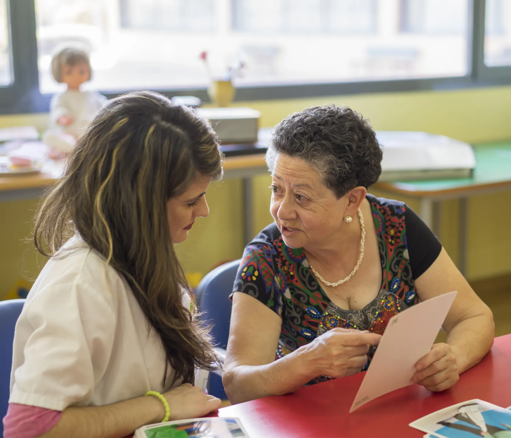 Una mujer mayor hablando animadamente con un profesional de ILUNION