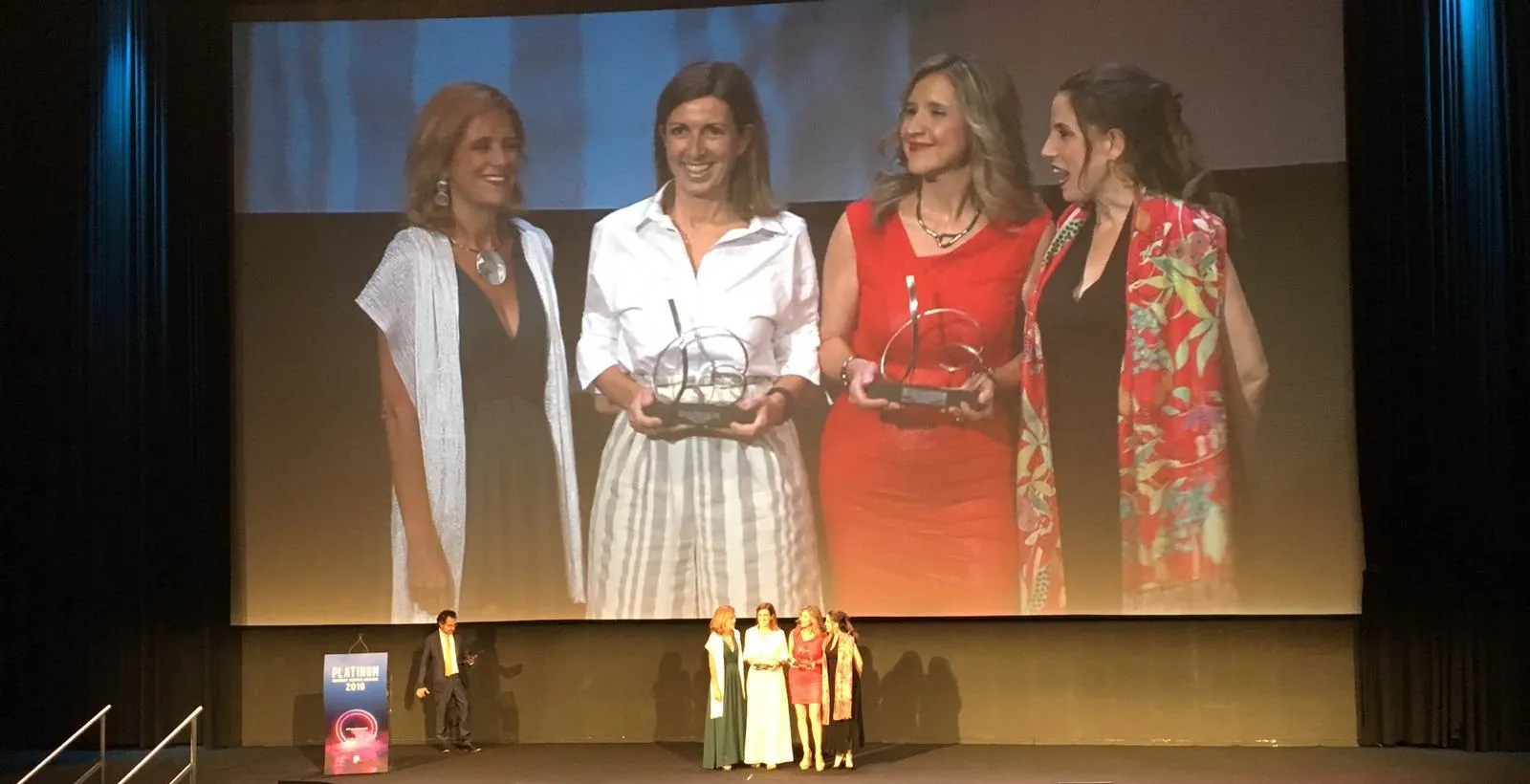 Fotografía durante la recogida del premio en la que aparecen cuatro personas, entre ellas la directora general de ILUNION Contact Center BPO, Susana Sánchez