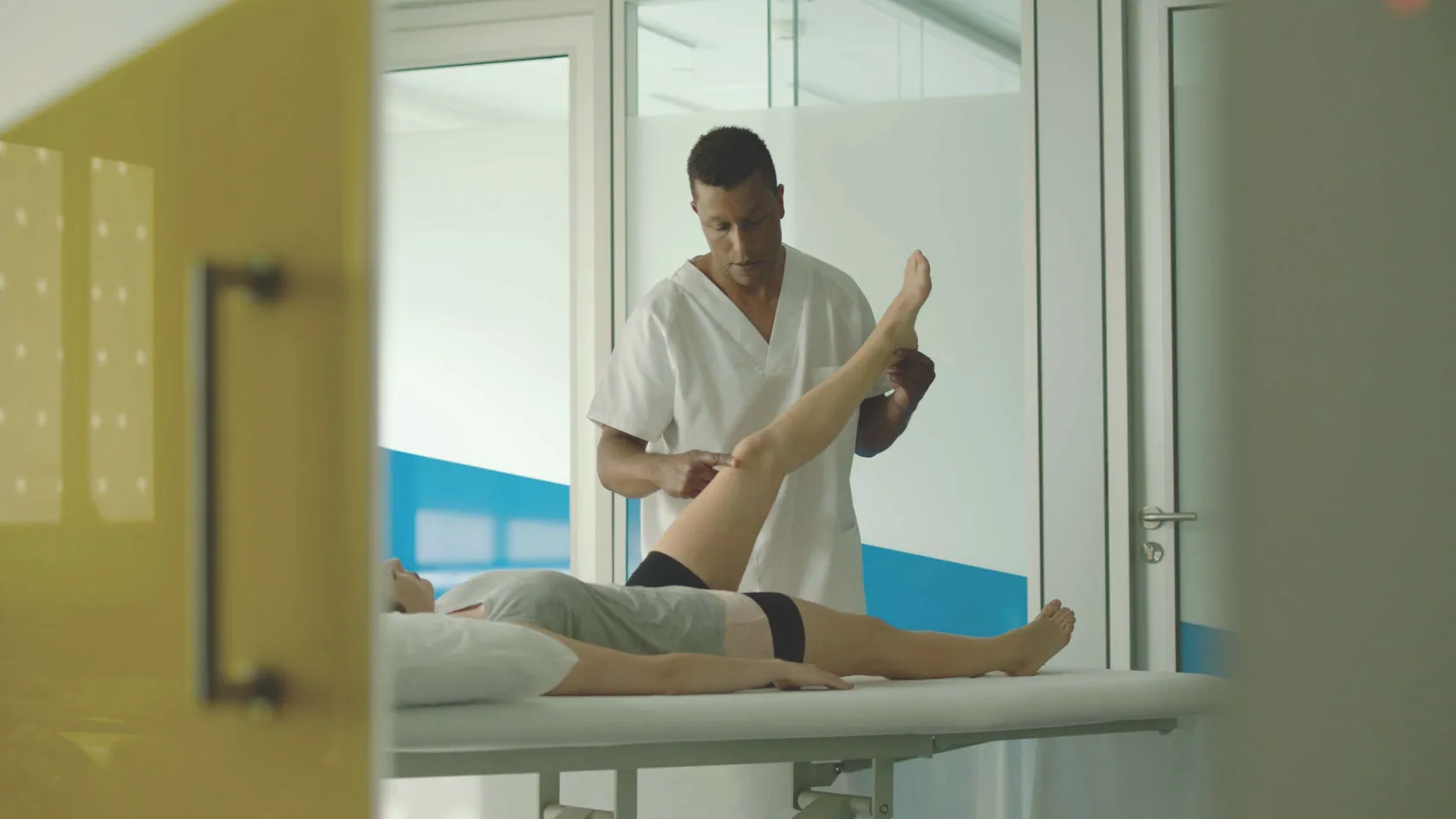 Fotografía en la que aparece un fisioterapeuta de Ilunion Fisioterapia y Salud tratando a una paciente