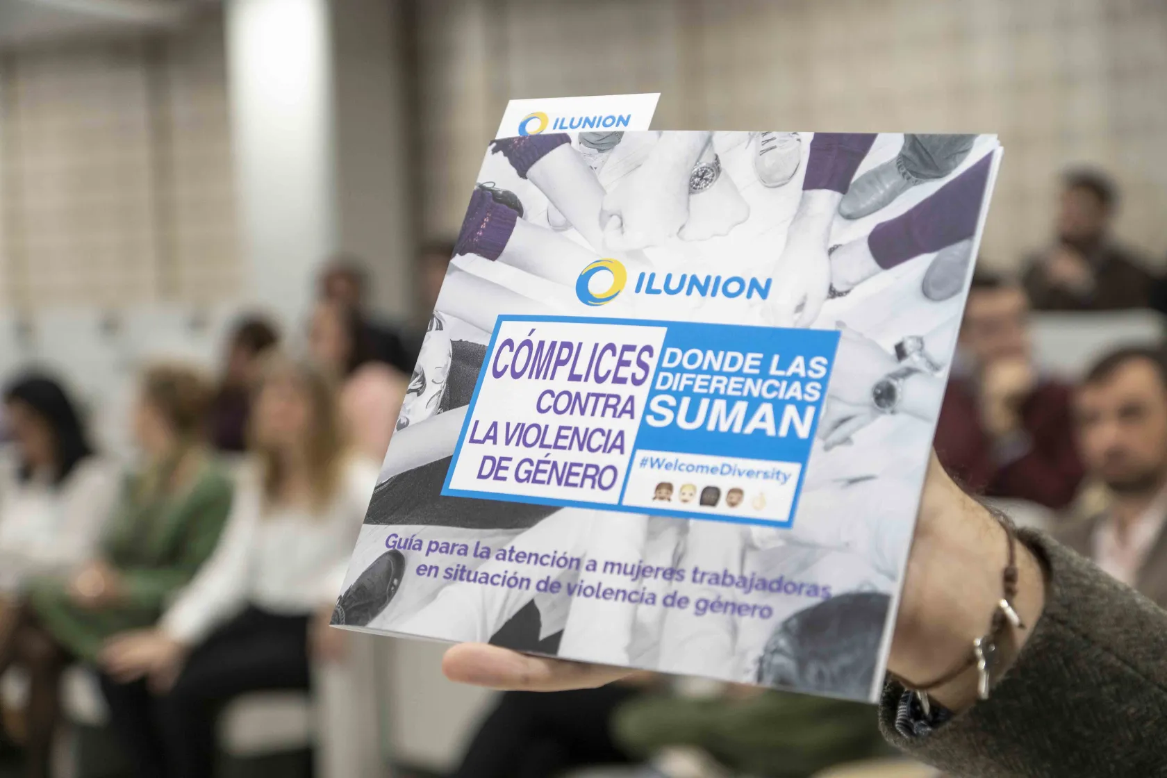 La mano de una mujer sostiene la guía "Cómplices contra la violencia de género"