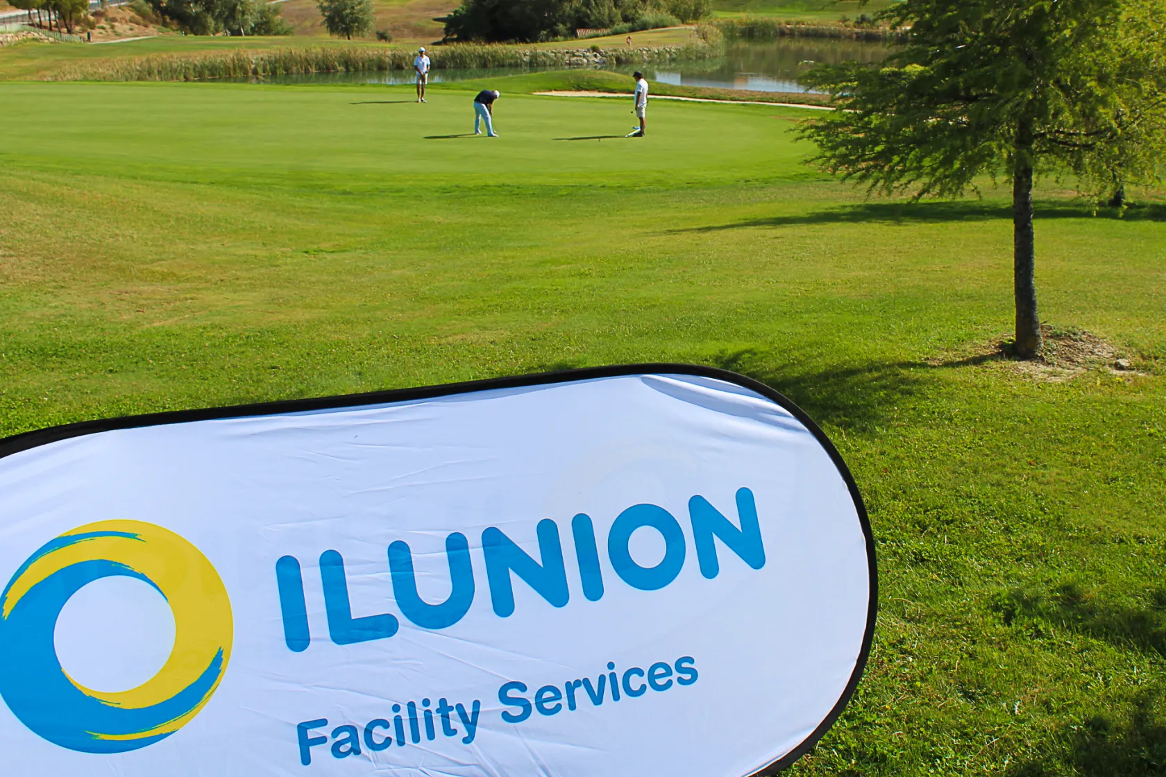 Fotografía de un campo de golf en el que hay un cartel de ILUNION Facility Services 