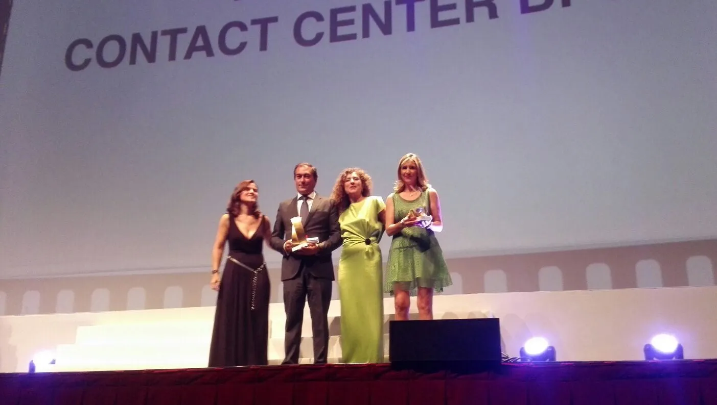 La directora general de ILUNION Contact Center recibe uno de los premios en el escenario 