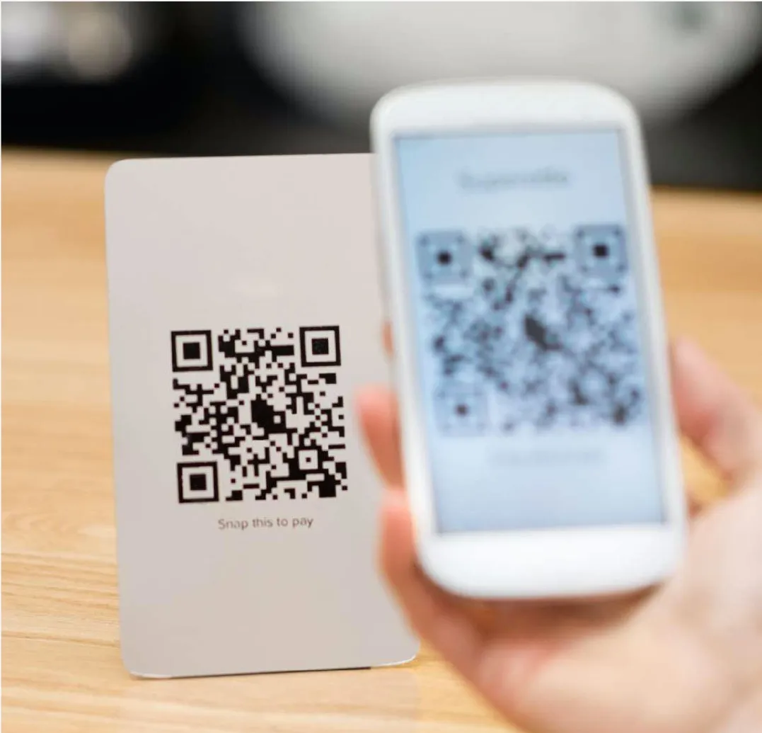 Una mano sostiene un teléfono móvil escaneando un código QR