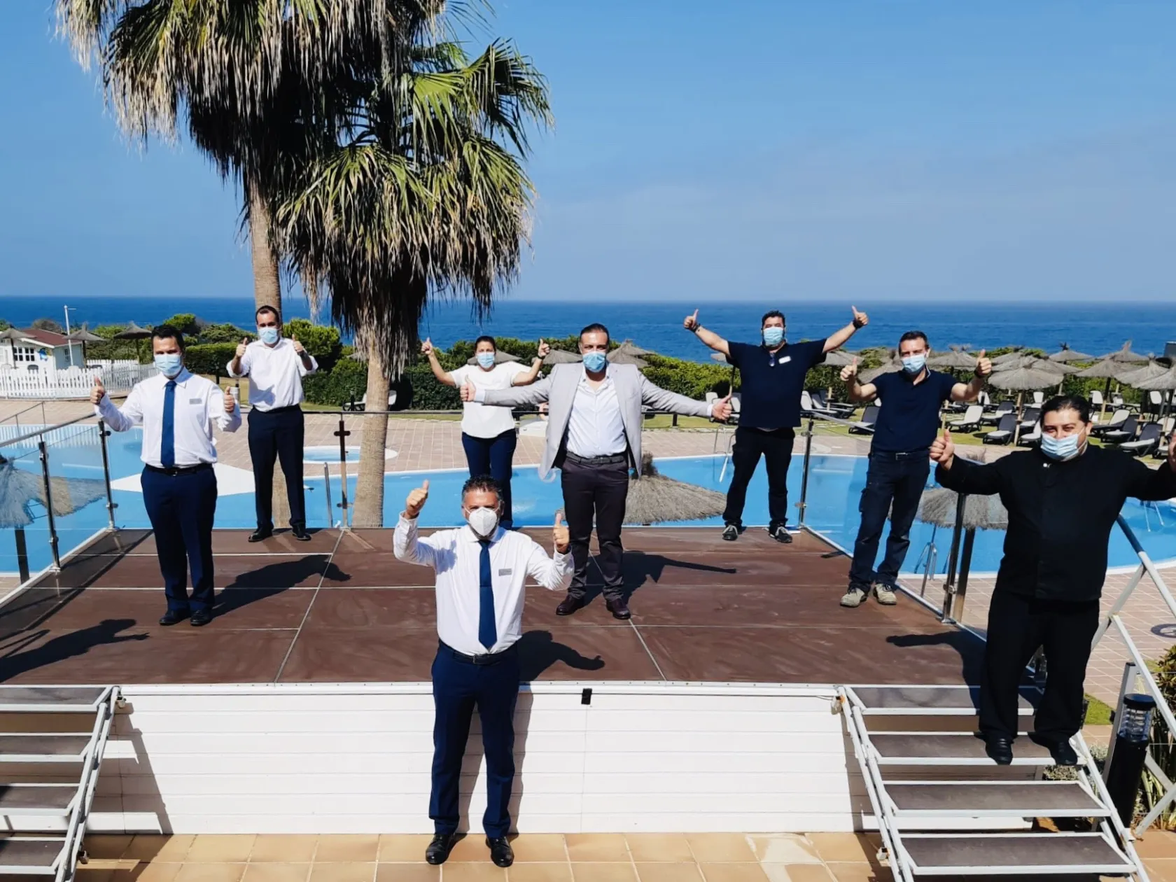 Foto de algunos de los trabajadores del hotel con mascarilla y manteniendo la distancia de seguridad 