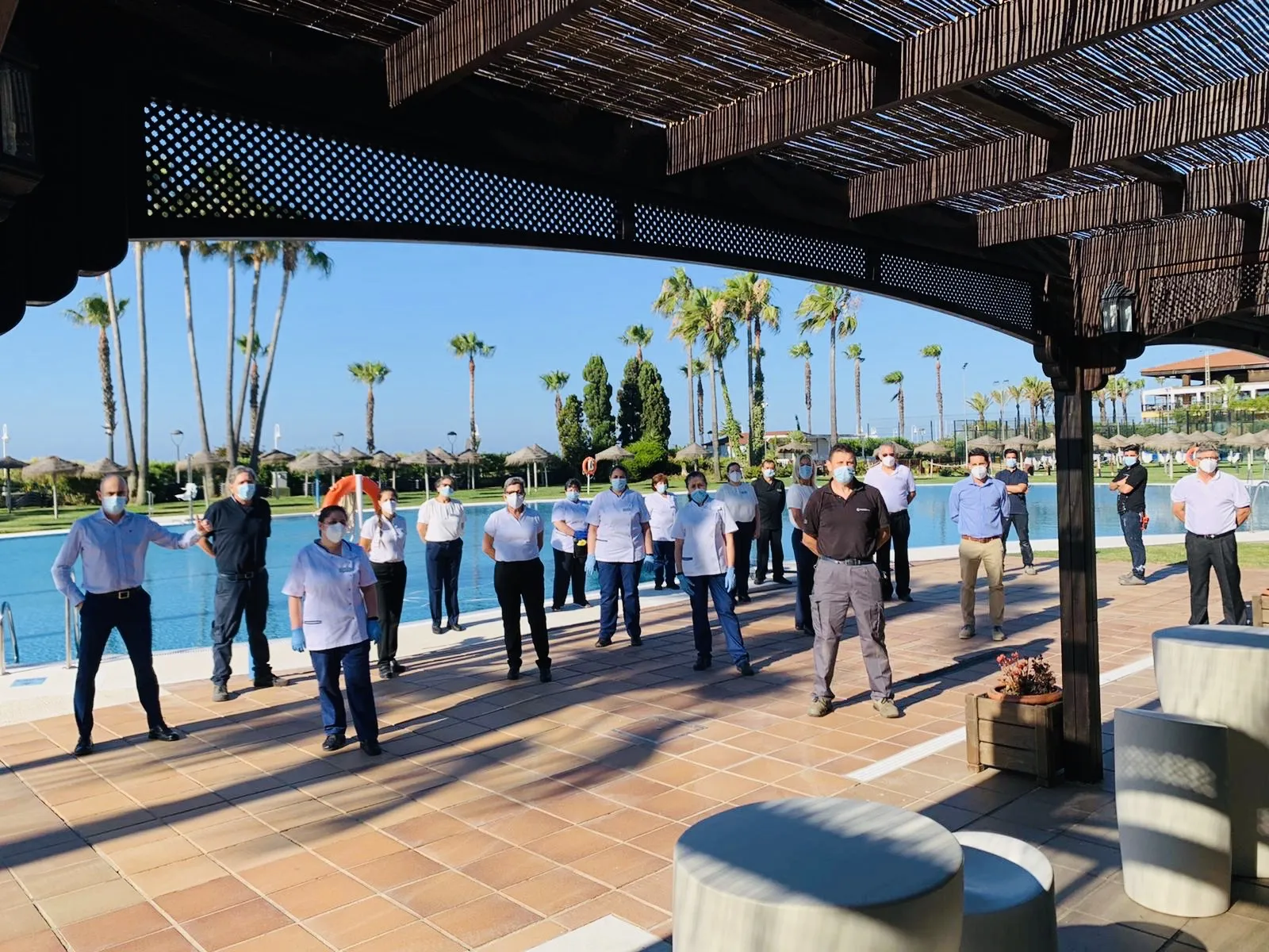 Foto de algunos de los trabajadores del hotel con mascarilla y manteniendo la distancia de seguridad 