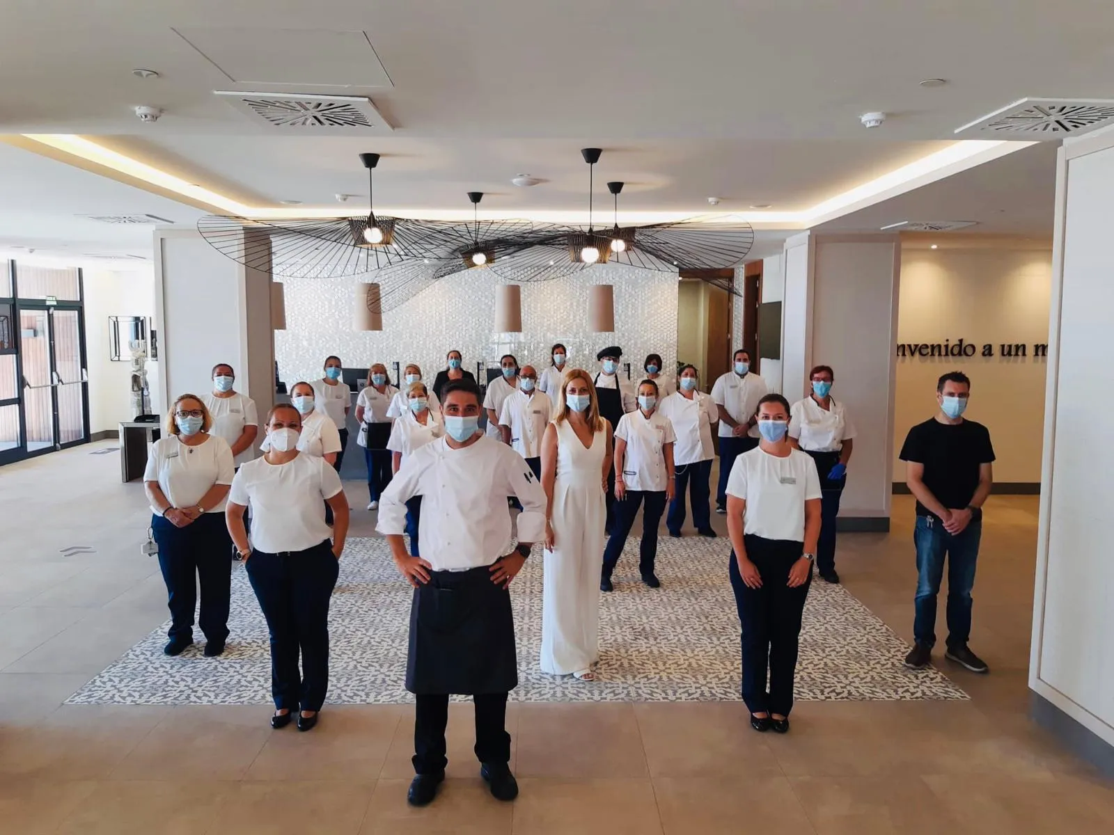 Imagen de los trabajadores manteniendo la distancia de seguridad y con sus epis en la recepción del ILUNION Fuengirola 