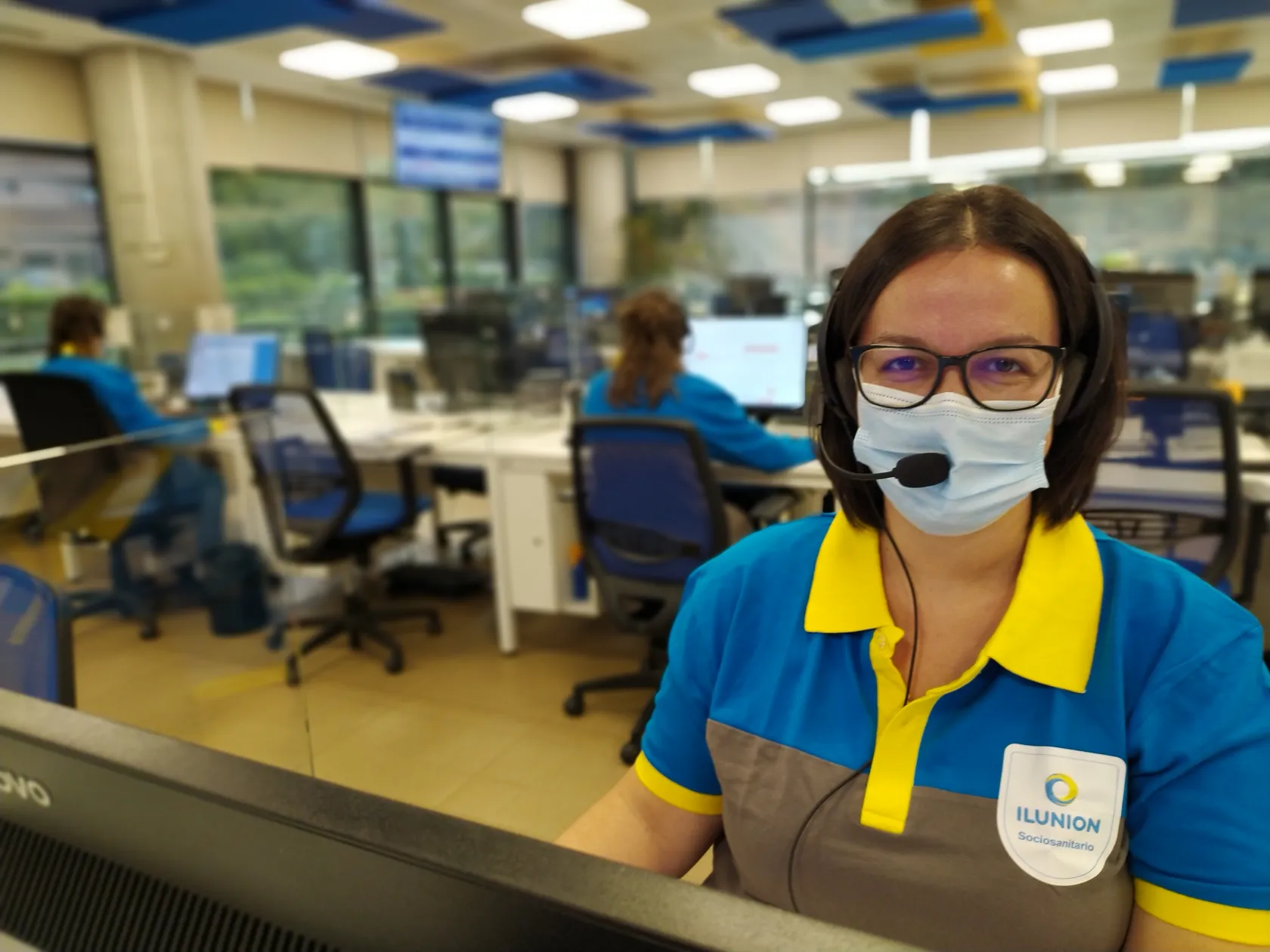 Una teleoperadora, con unas mascarilla, atiende una llamada de teleasistencia