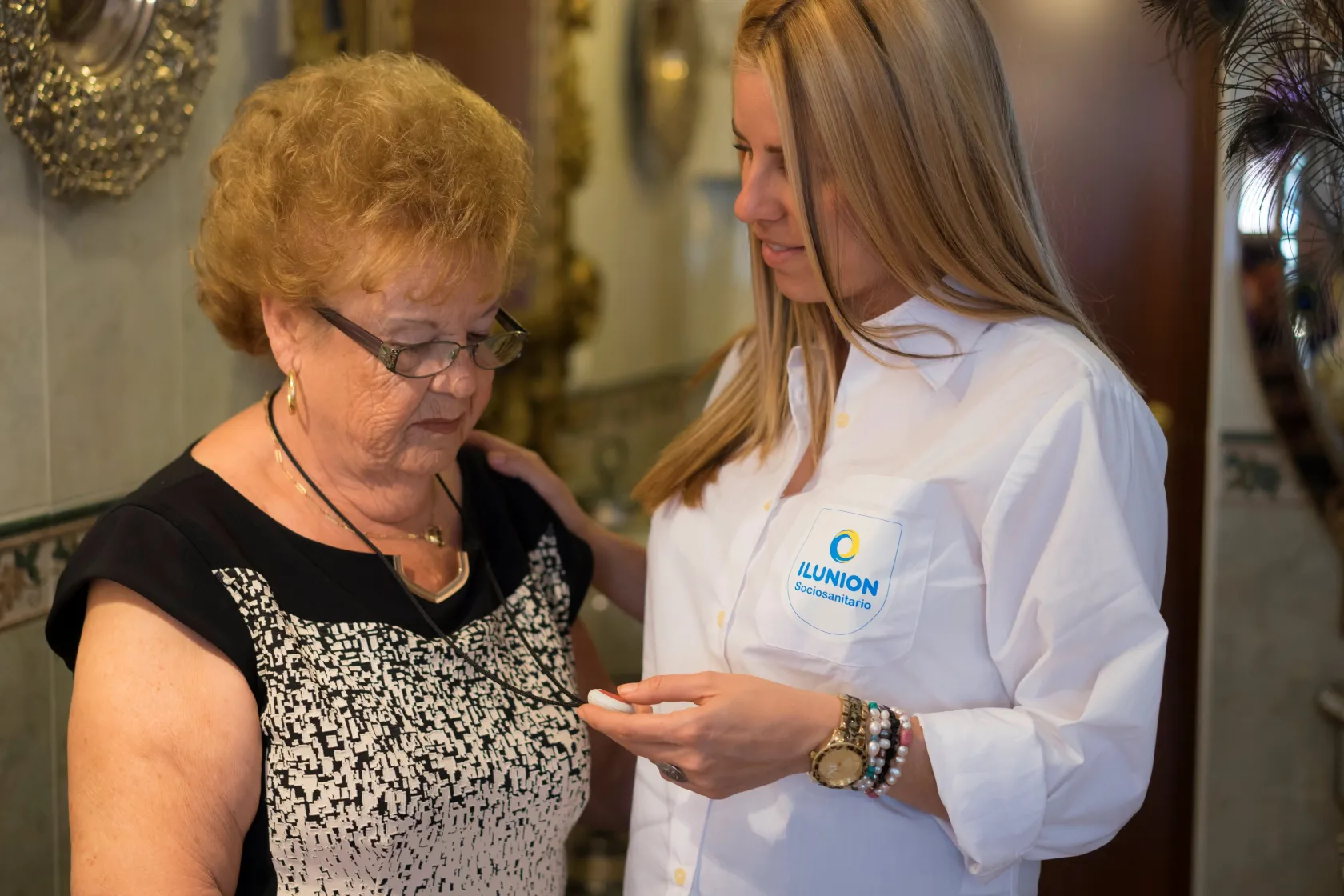 Una profesional de ILUNION Sociosanitario atendiendo a una mujer mayor en su domicilio