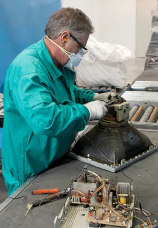 Trabajador de ILUNION reciclado desmontando un televisor