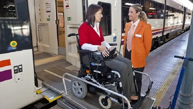 Una persona, usuaria de silla de ruedas, atendida por profesionales de Atendo