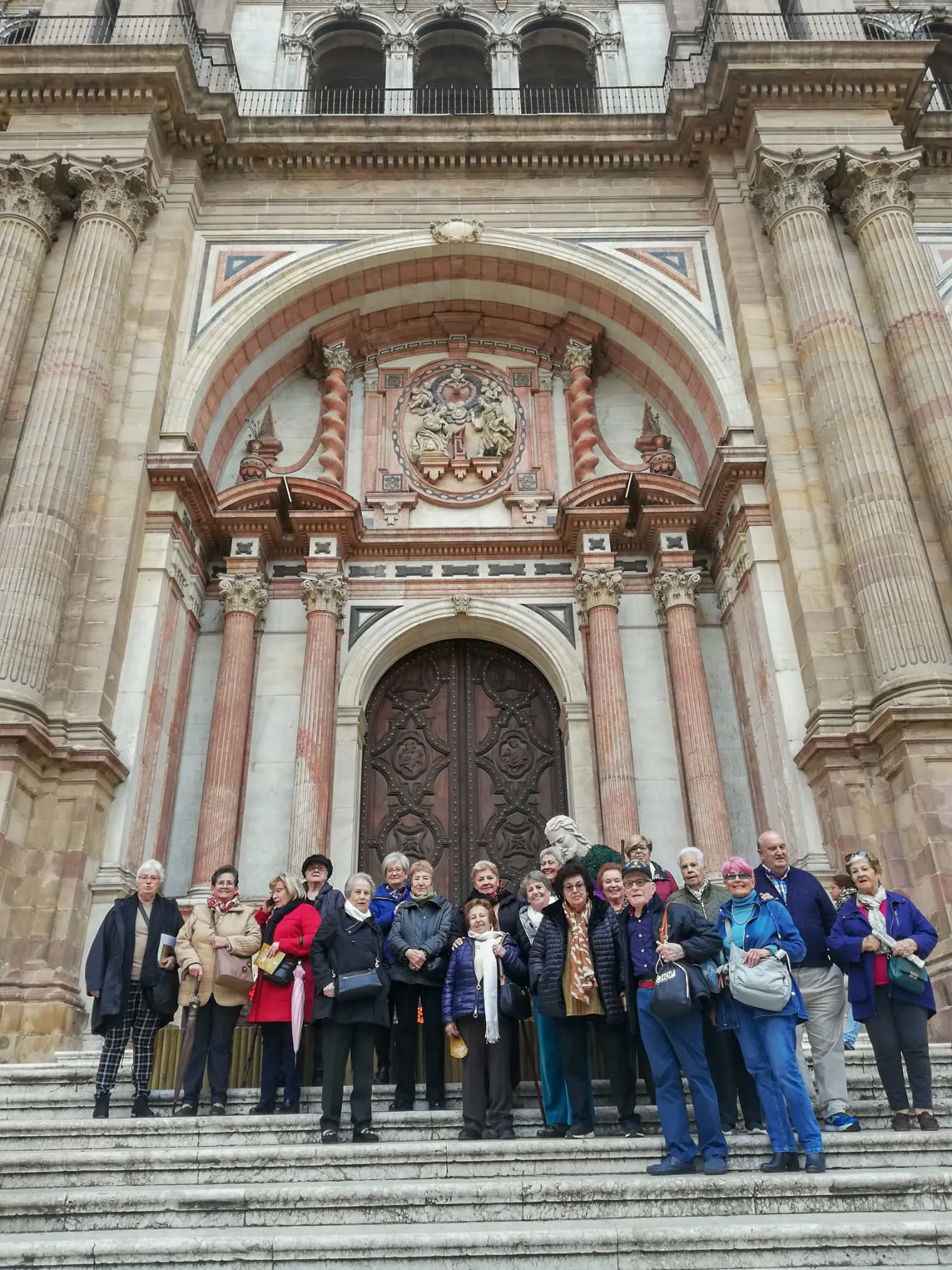 Personas usuarias del servicio de ayuda a domicilio de Torremolinos delante de la catedral de Málaga